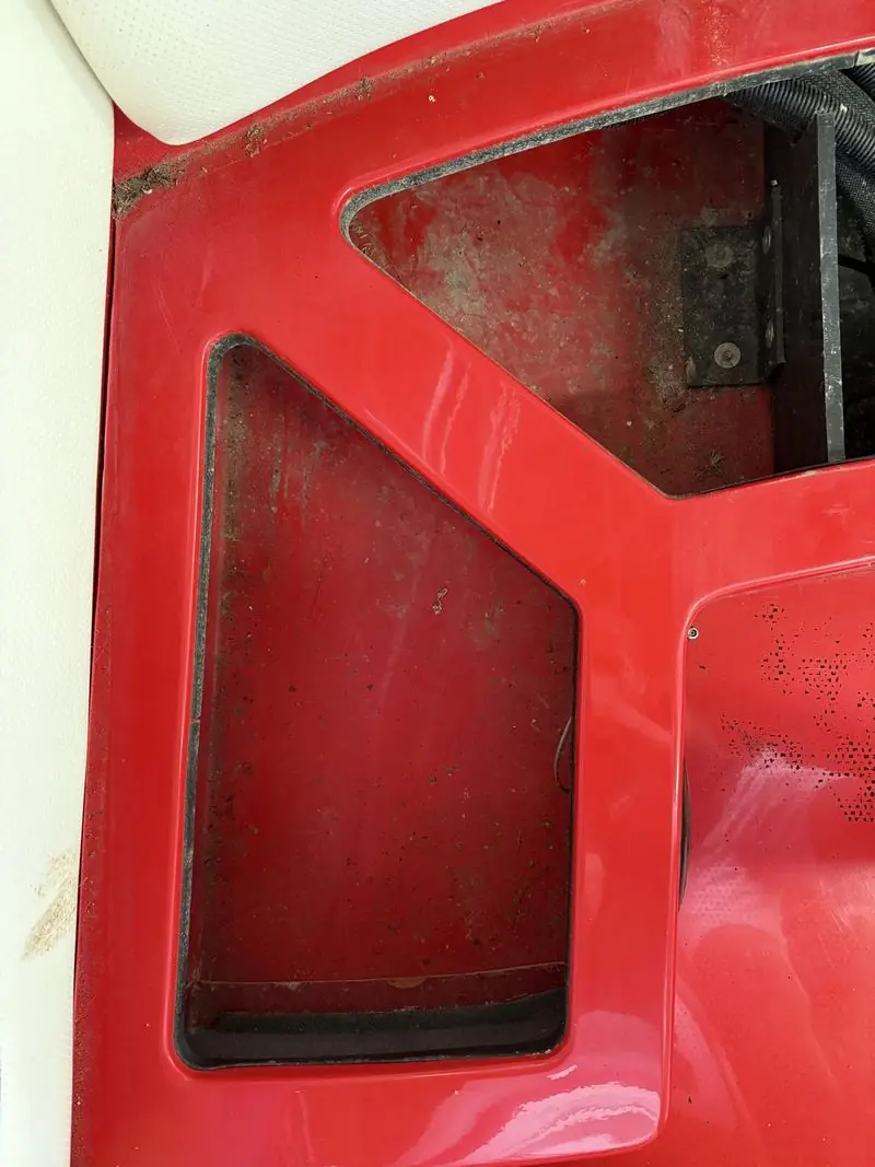Red storage compartment before detailing, grimy