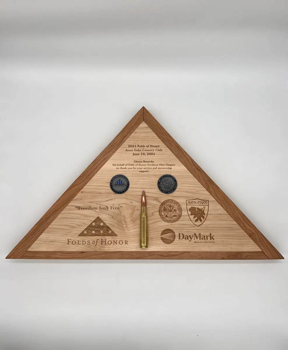 Triangular wooden flag case with engraved text and logos, two challenge coins and a brass cartridge